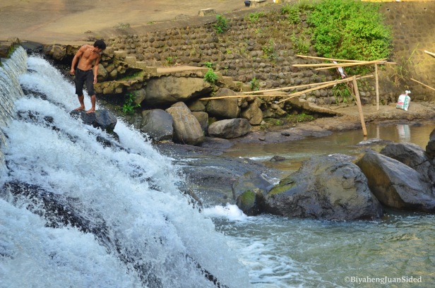 a person taking a bath at the falls at the ecopark